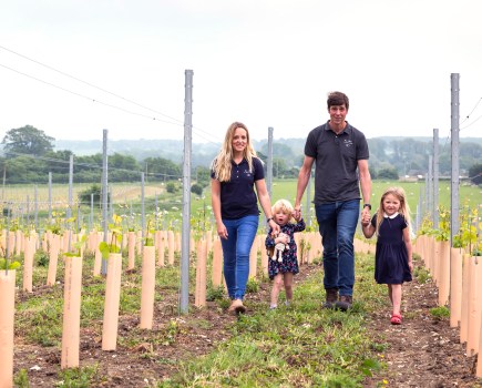 Husband, wife, 2 children in vineyard