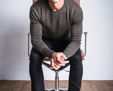 Guy sitting on a chair leaning forward